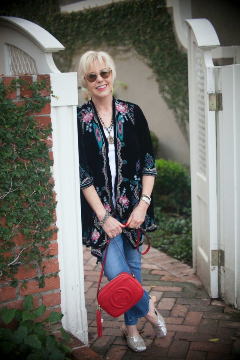 an embroidered jacket and metallic mules zhush up jeans and a tee