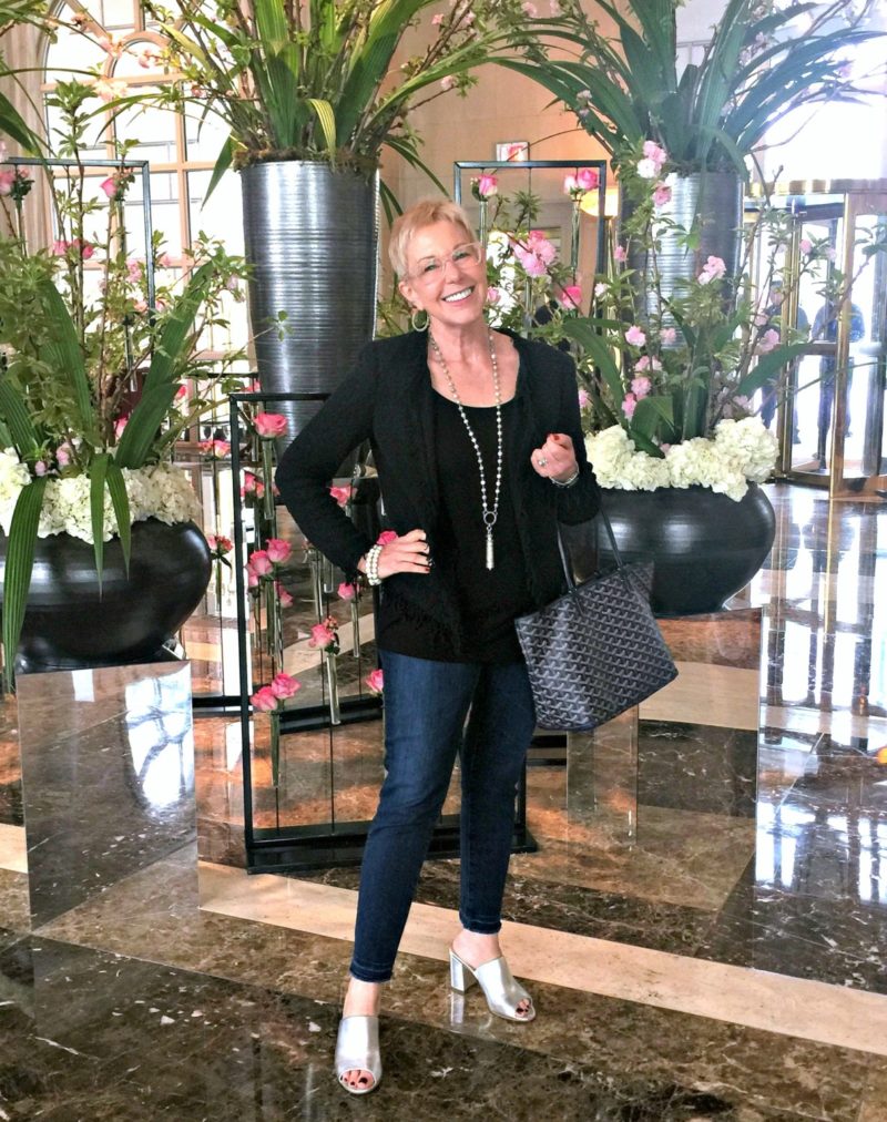 style blogger Susan B. wears a black bouclé jacket, jeans, and metallic sandals. Details at une femme d'un certain age.