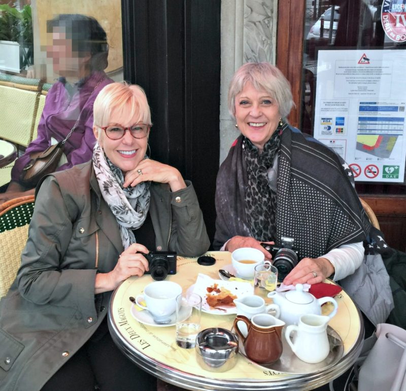 Style bloggers Susan B. of une femme d'un certain age and Josephine of Chic at Any Age enjoy a coffee at Les Deux Magots in Paris.