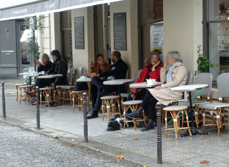 stylish people at a sidewalk cafe in Paris.