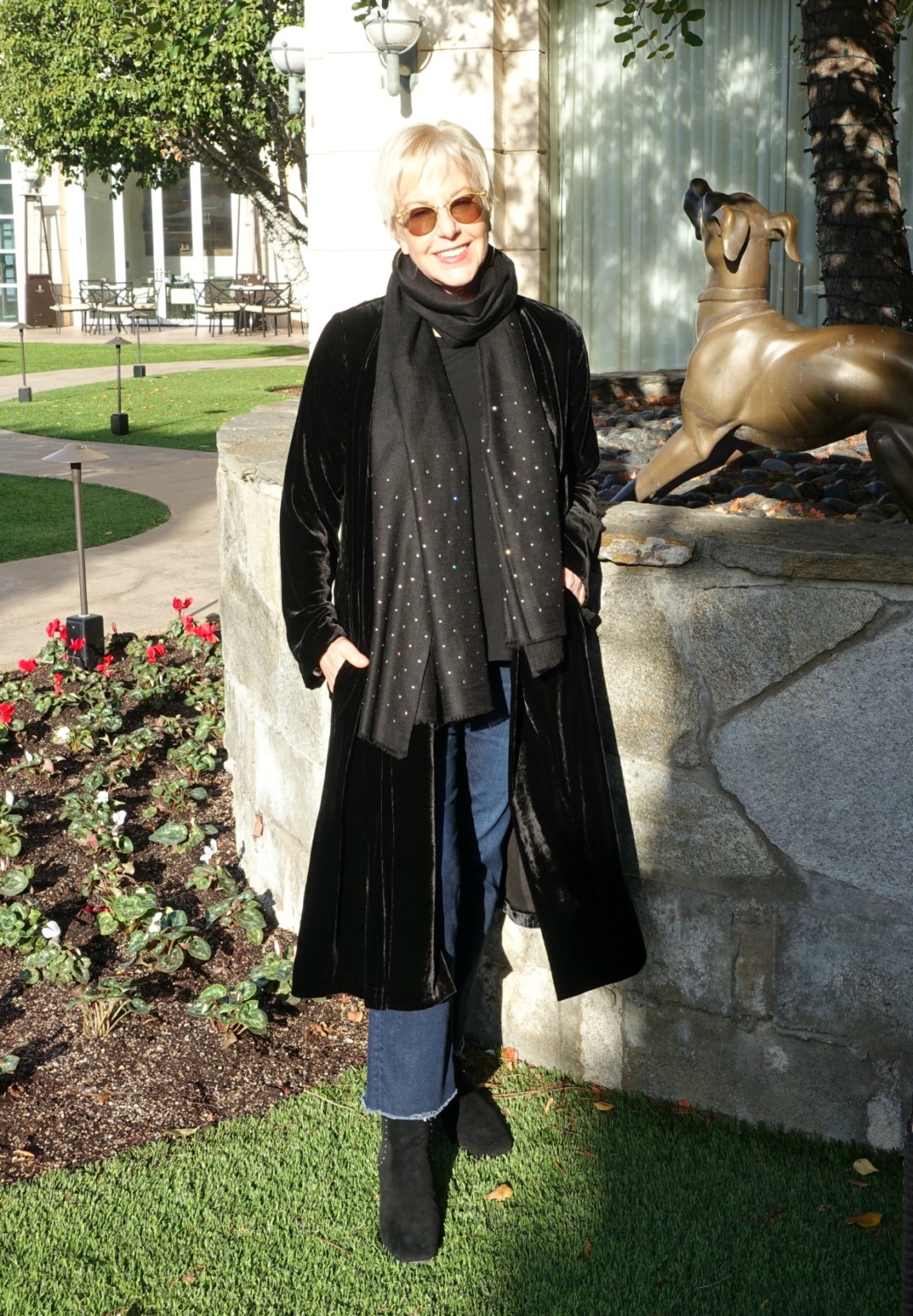 Susan B. wears a black velvet duster, black scarf with Swarovski crystals, jeans, and black suede boots. Details at une femme d'un certain age.