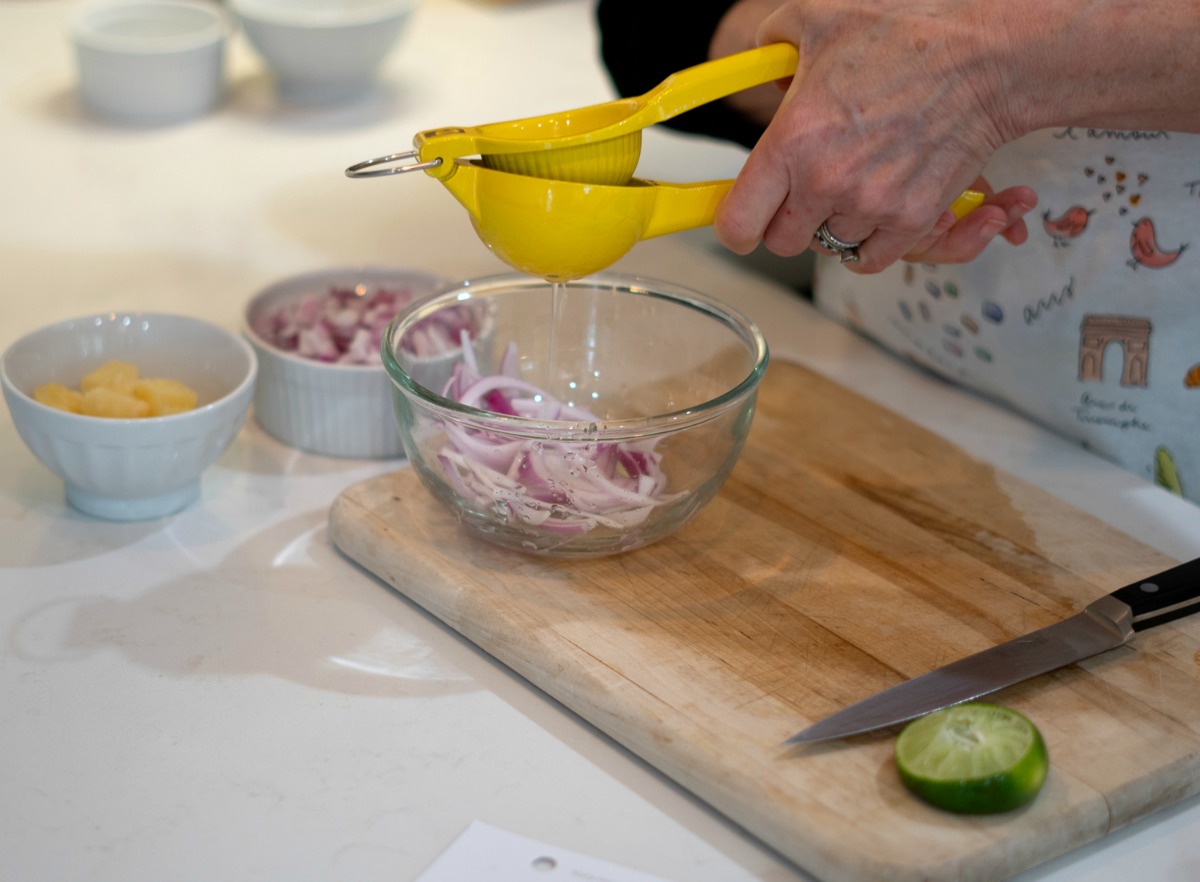 Squeezing lime juice to make pickled onion garnish. Details at une femme d'un certain age.