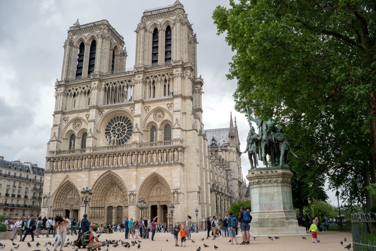 Front of Notre Dame in Paris with tourists and statue. Details at une femme d'un certain age.