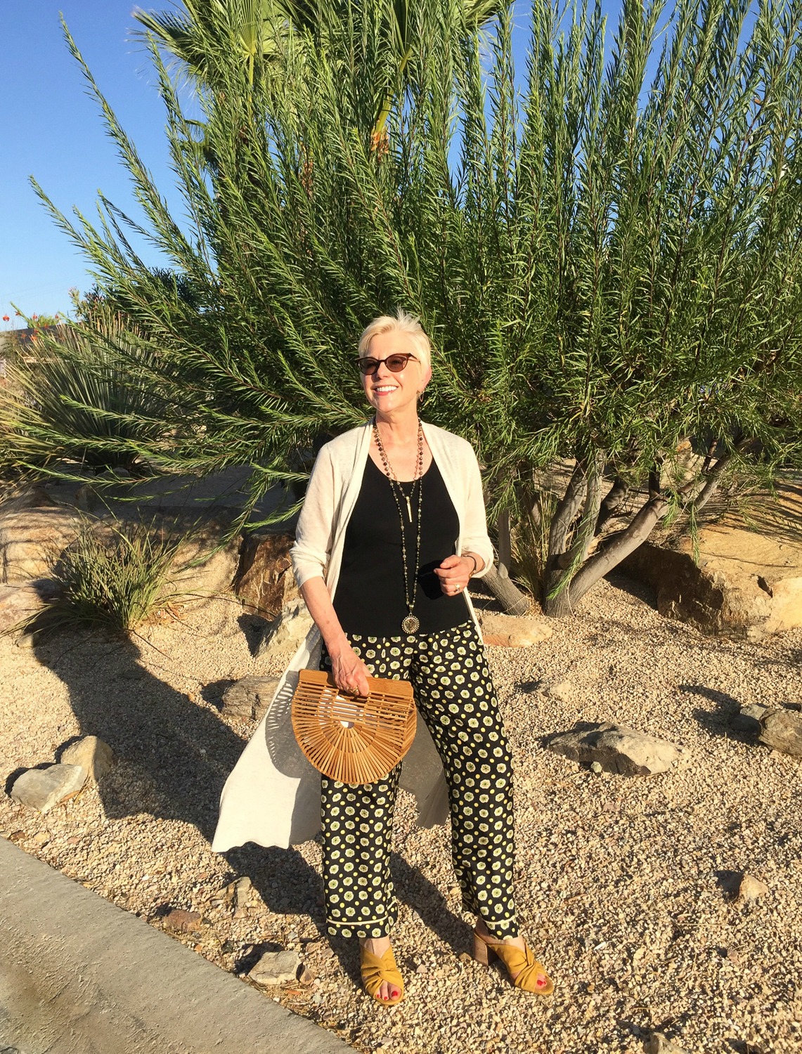 Casual Summer Party Look: Style blogger Susan B. wears printed pants, a duster cardigan, bamboo bag and yellow slide sandals. Details at une femme d'un certain age.