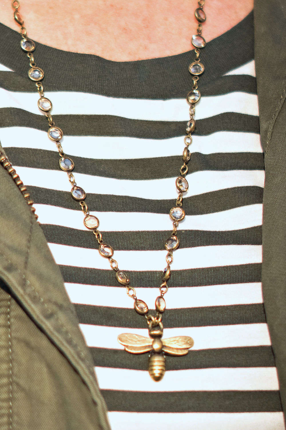 Style blogger Susan B. wears a crystal necklace with bee pendant and striped tee. Details at une femme d'un certain age.