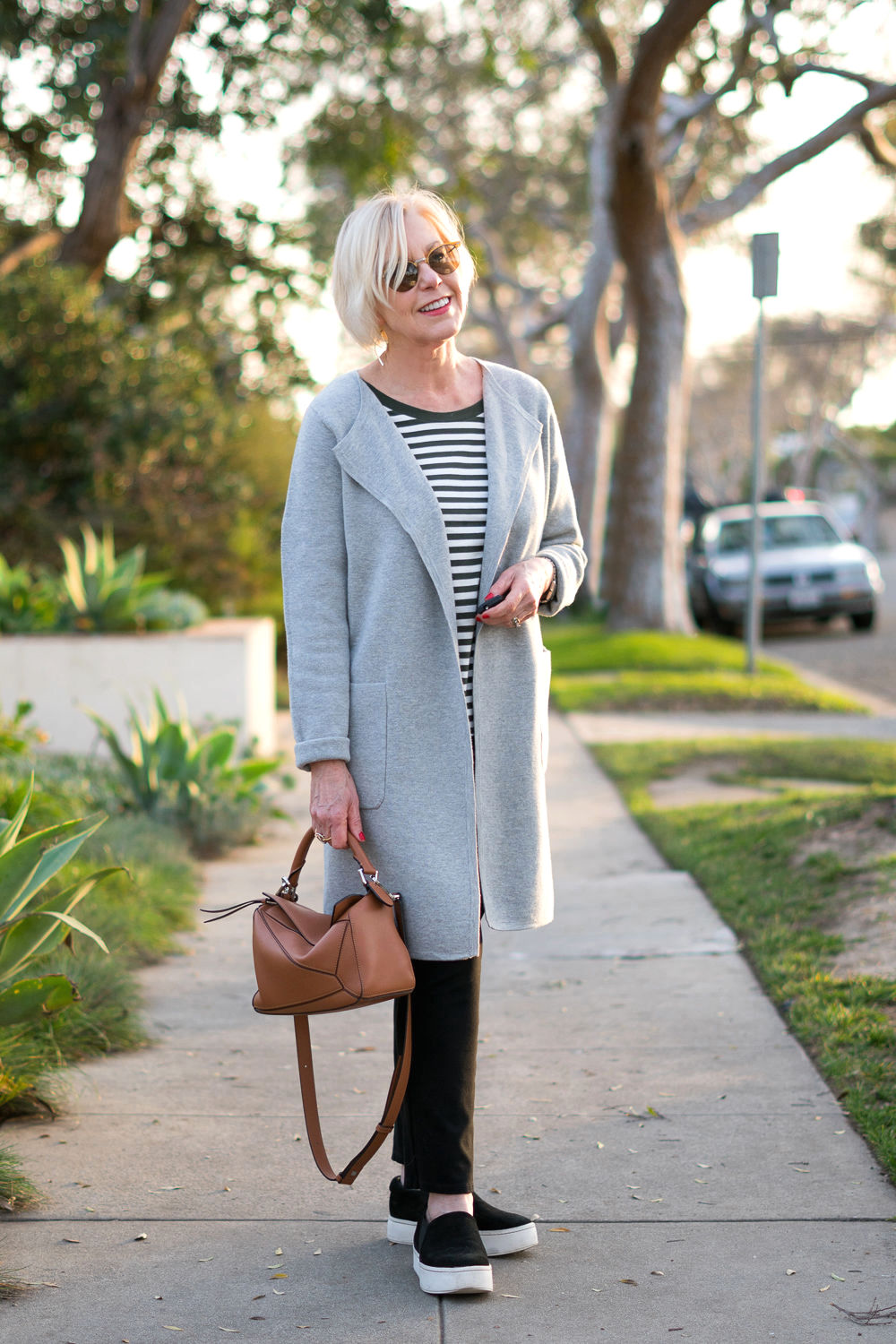 Style blogger Susan B. wears a sporty casual look with a striped tee and grey sweater coat. Details at une femme d'un certain age.