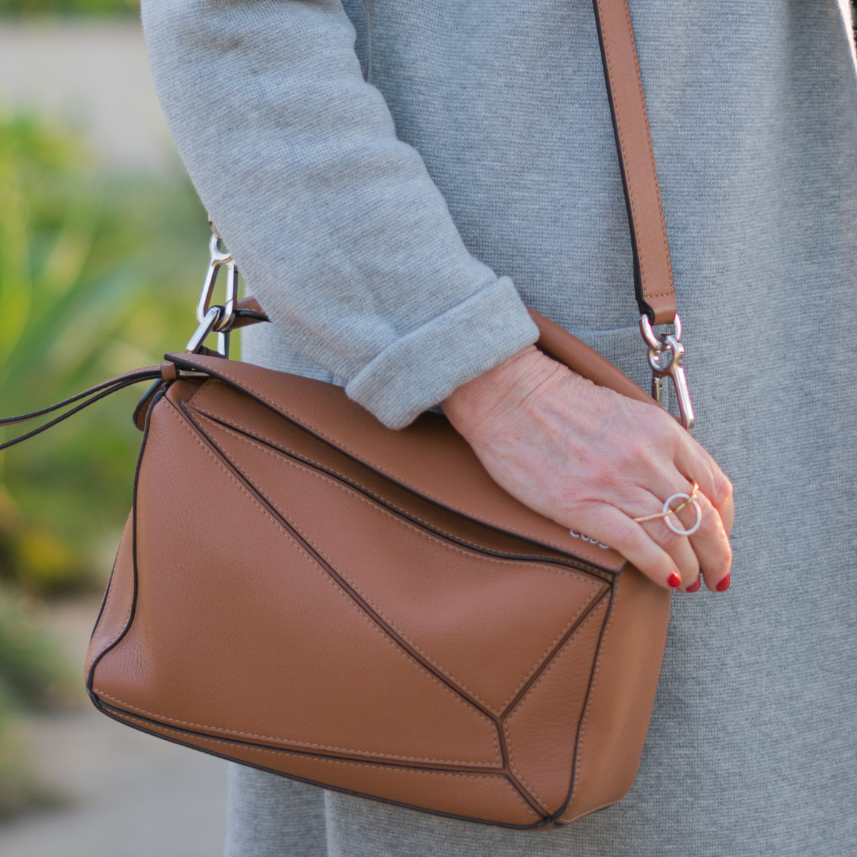 Detail: style blogger Susan B. of une femme d'un certain age wears a Loewe small puzzle bag, and Charlotte Chesnais triple ring.