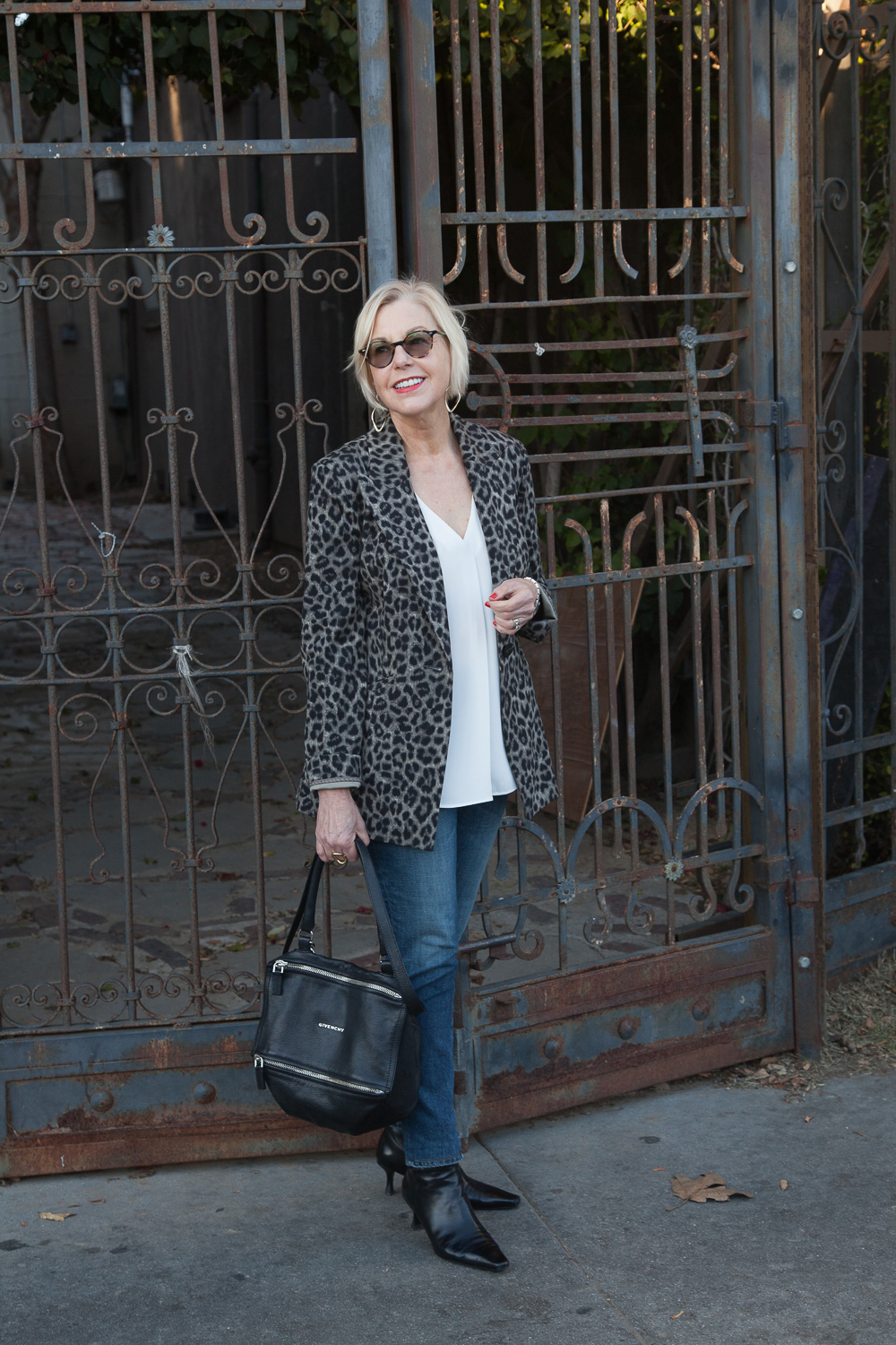 Style blogger Susan B. of une femme d'un certain age wears a casual date night look with a leopard jacket from cabi, jeans, and black boots.