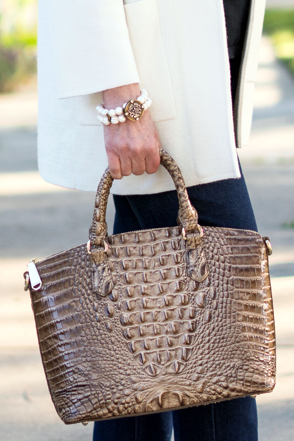 Detail: Susan B wears a French Kande pearl bracelet and carries a Brahmin croc-effect bag. Info at une femme d'un certain age.