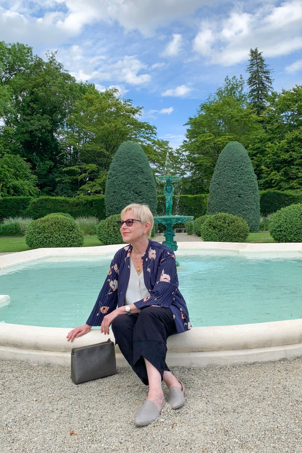 Susan B. of une femme d'un certain sits by fountain in Levernois, France.