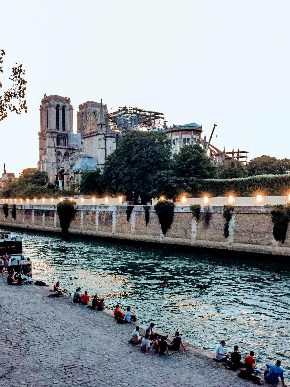 View of Notre Dame after fire from Left Bank. Details at une femme d'un certain age.