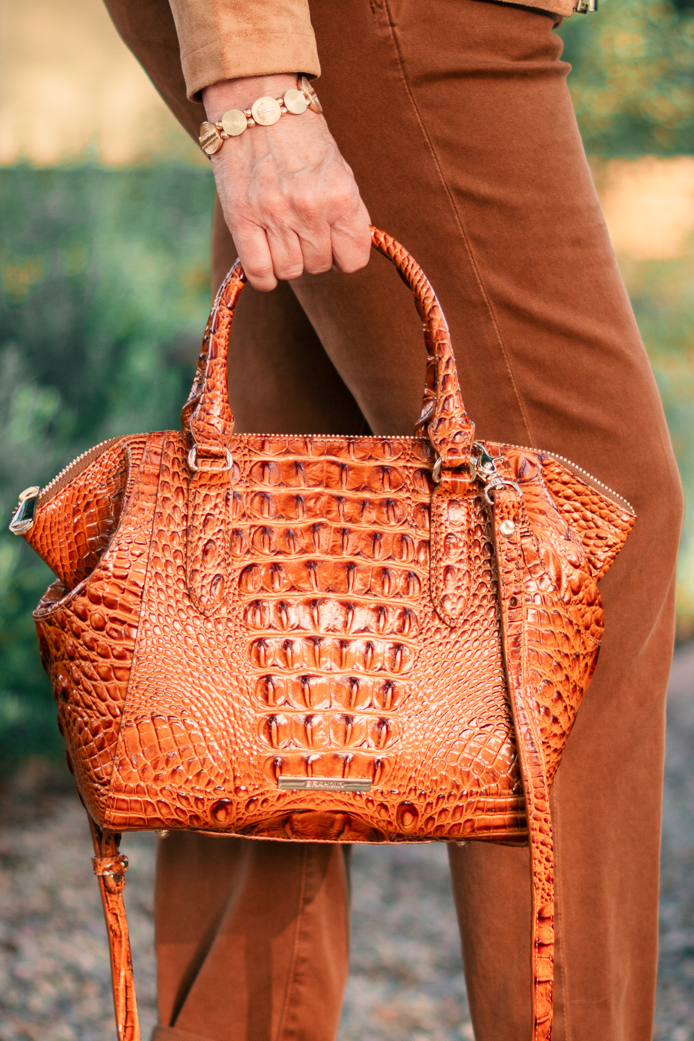 Detail: Susan Blakey of une femme d'un certain age carries a Brahmin croc-effect bag.