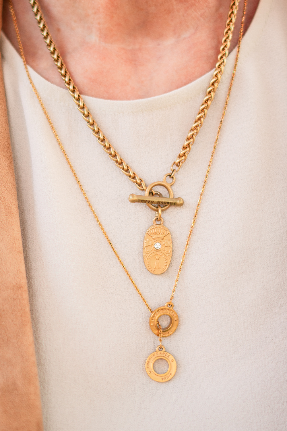 Susan B. of une femme d'un certain age wears layered gold necklaces from the French Kande FK Petite collection.