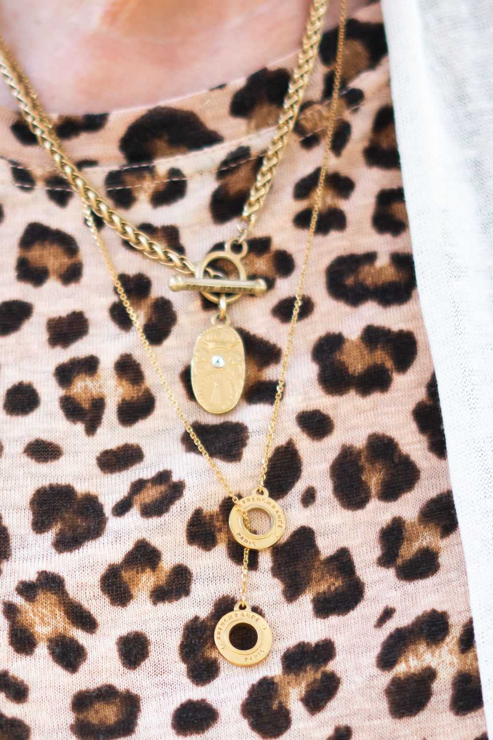 Detail: French Kande FK Petite gold necklaces with a leopard tee. Info at une femme d'un certain age.