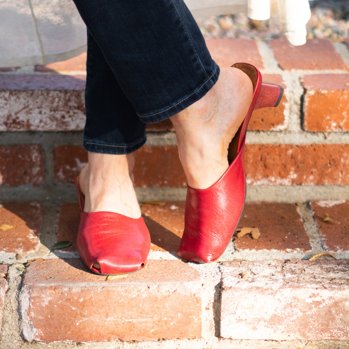 Susan B of une femme d'un certain age wears red square-toe mules.