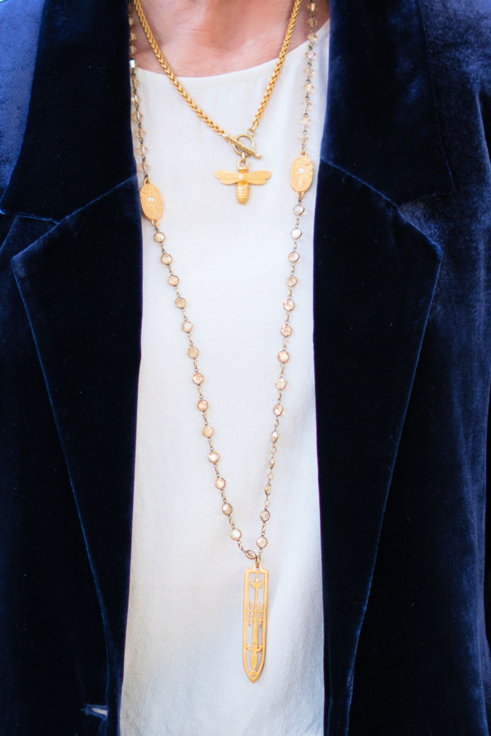 Susan B. of une femme d'un certain age wears layered gold French Kande necklaces.