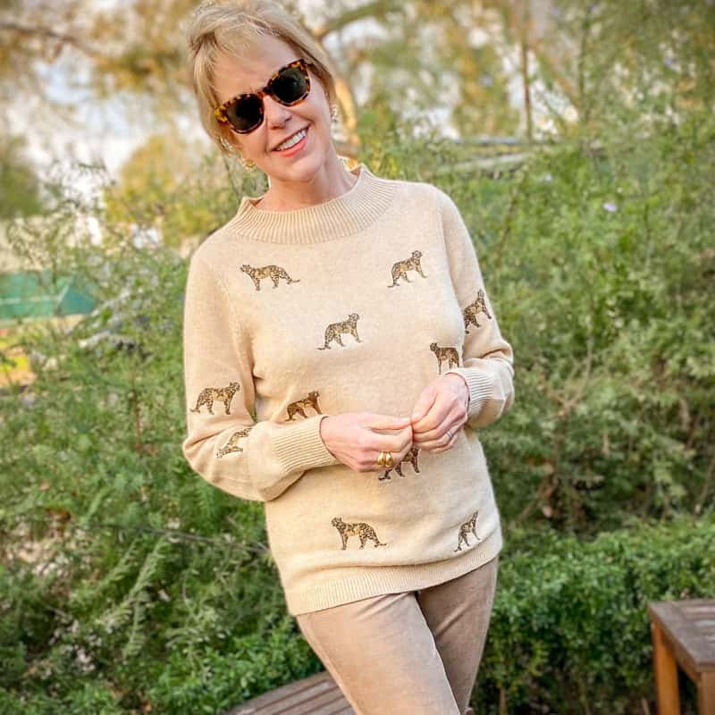 Detail: Susan B wears a cashmere sweater with leopard embroidery. Info at une femme d'un certain age.