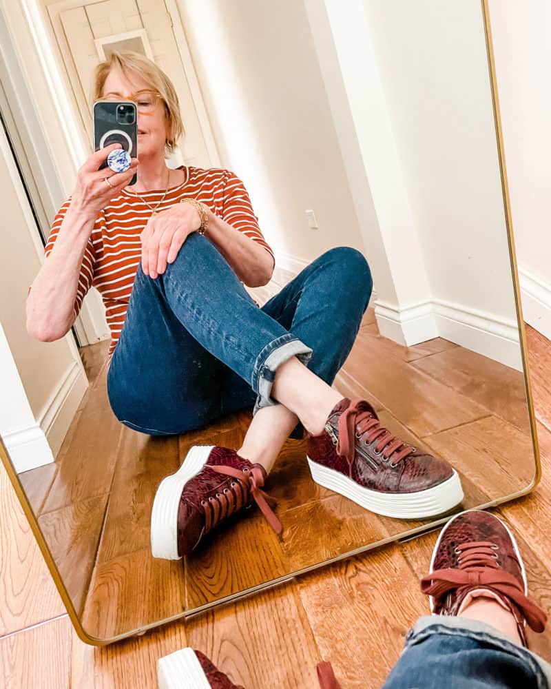 Susan B. wears Sole Bliss Hero sneakers in Bordeau, jeans and striped tee. More fall sneakers for women at une femme d'un certain age.