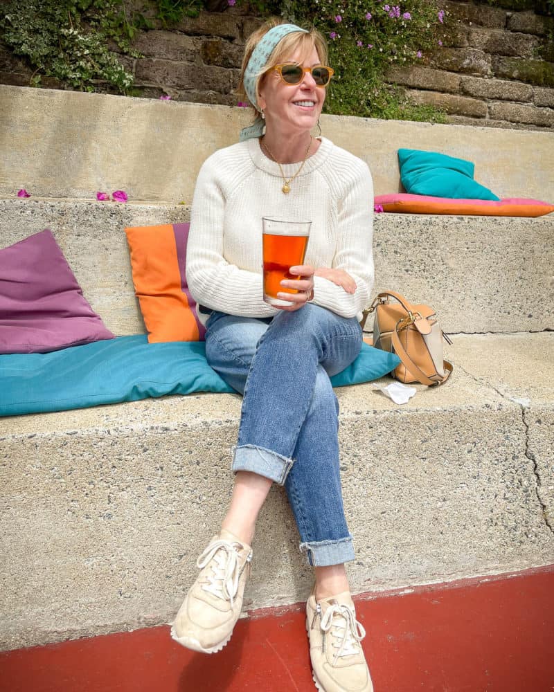 Susan B. enjoying a beer at Nepenthe. Wearing a Madewell bandana, Jenni Kayne cotton fisherman sweater, AG boyfriend jeans.