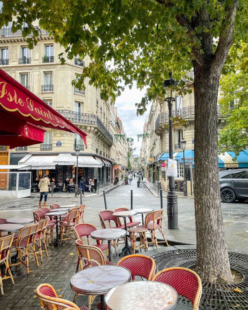 Cafe on Ile St. Louis in Paris with red chairs.