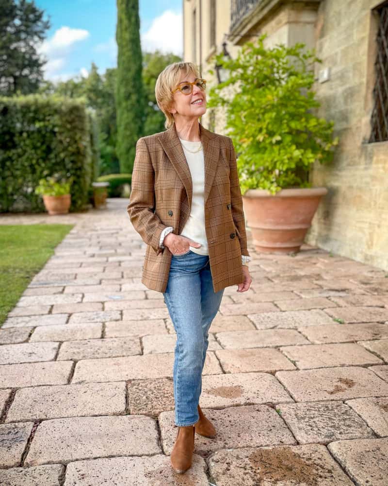 Susan B. wears a Weekend Max Mara jacket, ivory sweater and jeans, in front of a Tuscan villa.