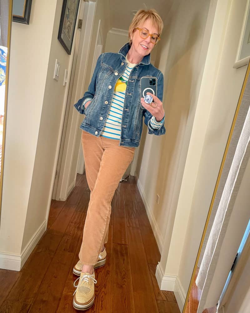 Susan B. wears a denim jacket, lemon print sweater, tan corduroys and raffia oxfords.
