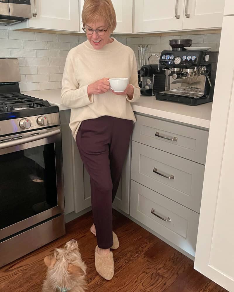 Susan B. wears EILEEN FISHER recycled cashmere top, cozy terry pants, shearling mules while Gigi looks on.