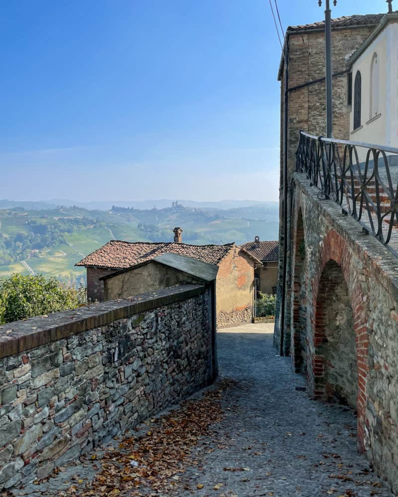 Hillside town with rolling hills in background in Piedmont, Italy.