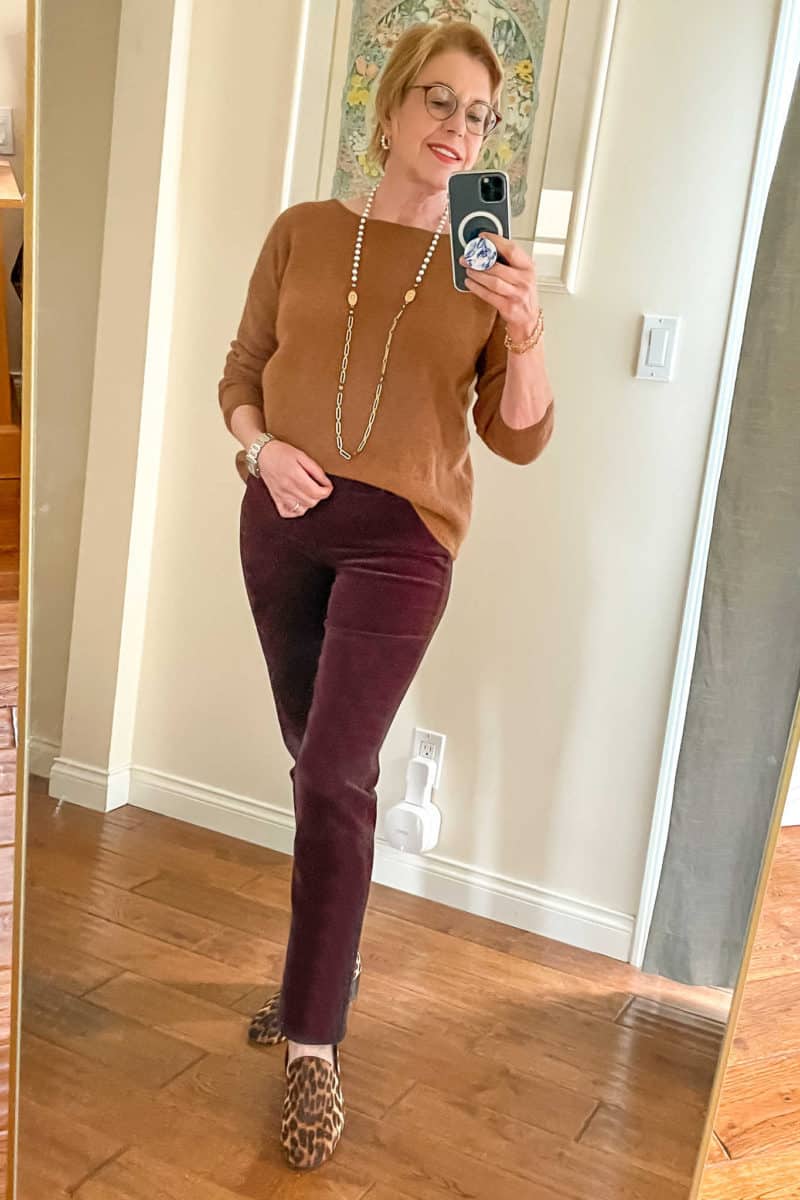 What to wear to host a casual holiday party: Susan B. wears a brown fuzzy sweater, long pearl & chain necklace, brown corduroy pants, leopard print loafers.