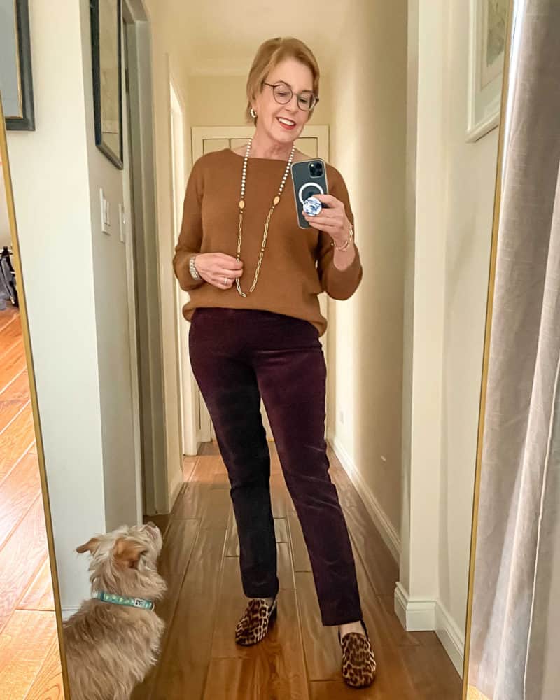 Casual holiday outfit: Susan B. wears a brown sweater, long pearl & chain necklace, brown corduroy pants, leopard loafers.