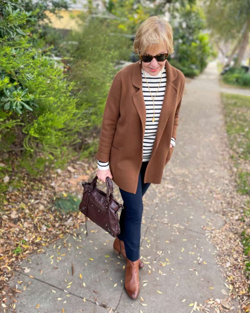 What to wear with navy pants: Susan adds a striped sweater, brown sweater jacket and boots.