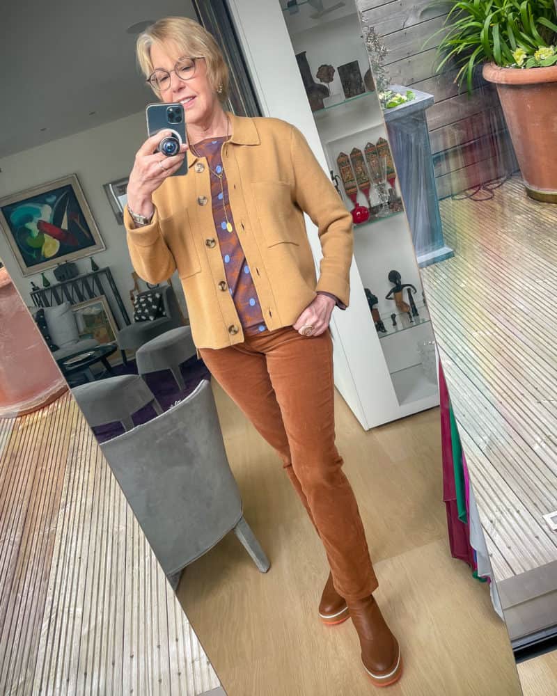 Susan B. wears the Madewell chore sweater jacket, print top, brown corduroy pants, Clergerie brown boots.