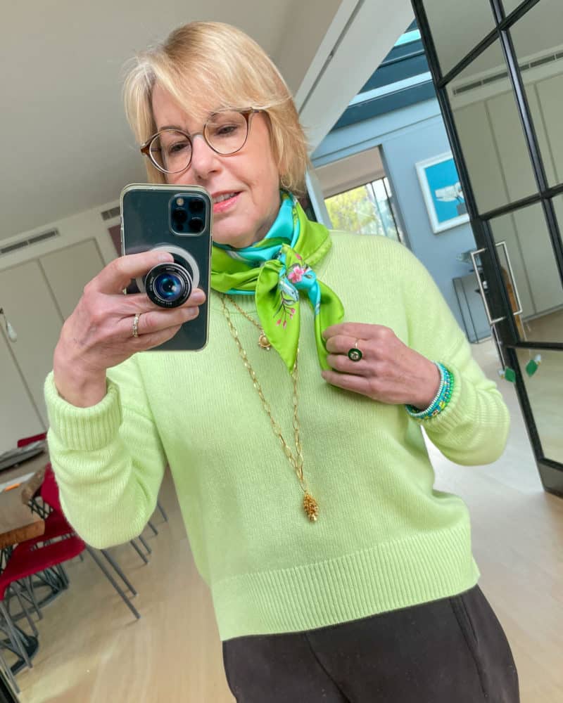 Susan B. wears a mint green Me+Em sweater, green and aqua scarf, and gold jewelry.