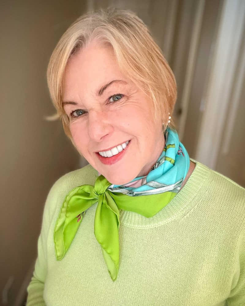 Susan B. wears a green and aqua silk scarf and mint green sweater.