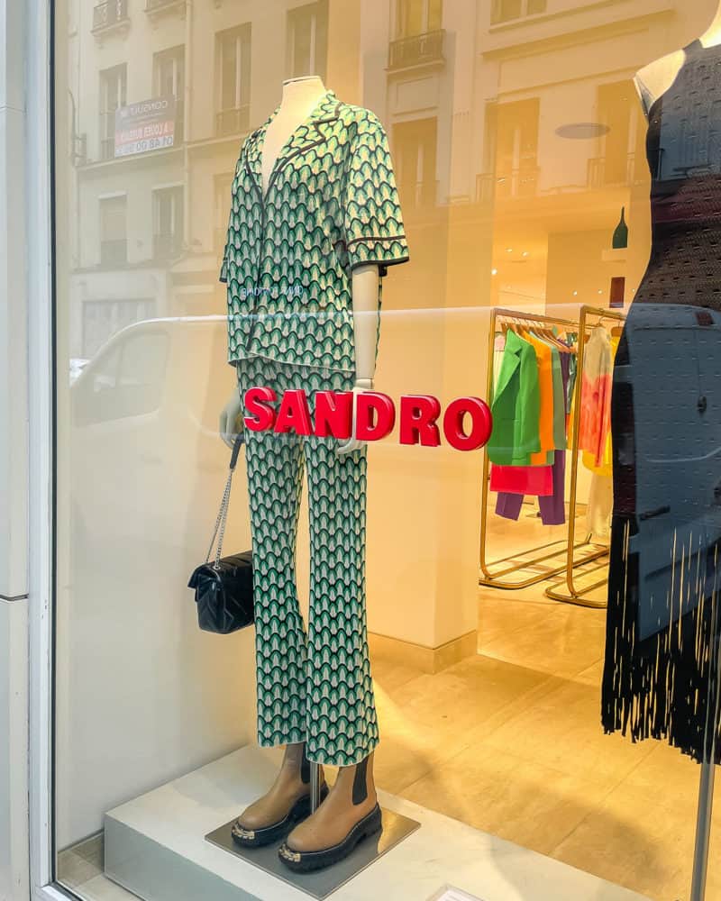 Sandro store window paris with green outfit.