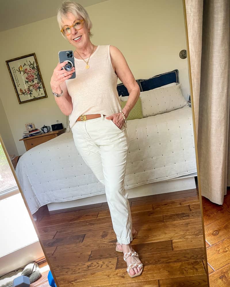 Wearing the Banana Republic slim utility pants with a gold pendant necklace, linen tank, Loewe leather belt, and braided strap flat sandals.