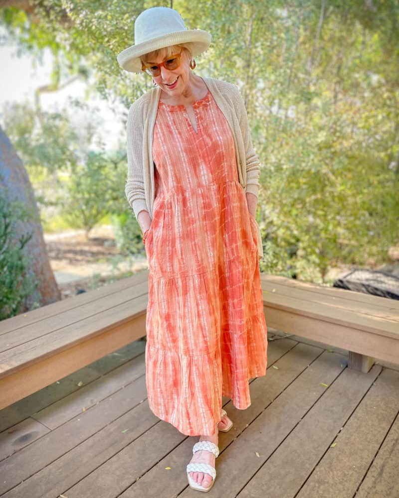How to wear a maxi dress: Susan B. wears a sun hat, tiered maxi dress, linen cardigan and flat braided strap sandals.
