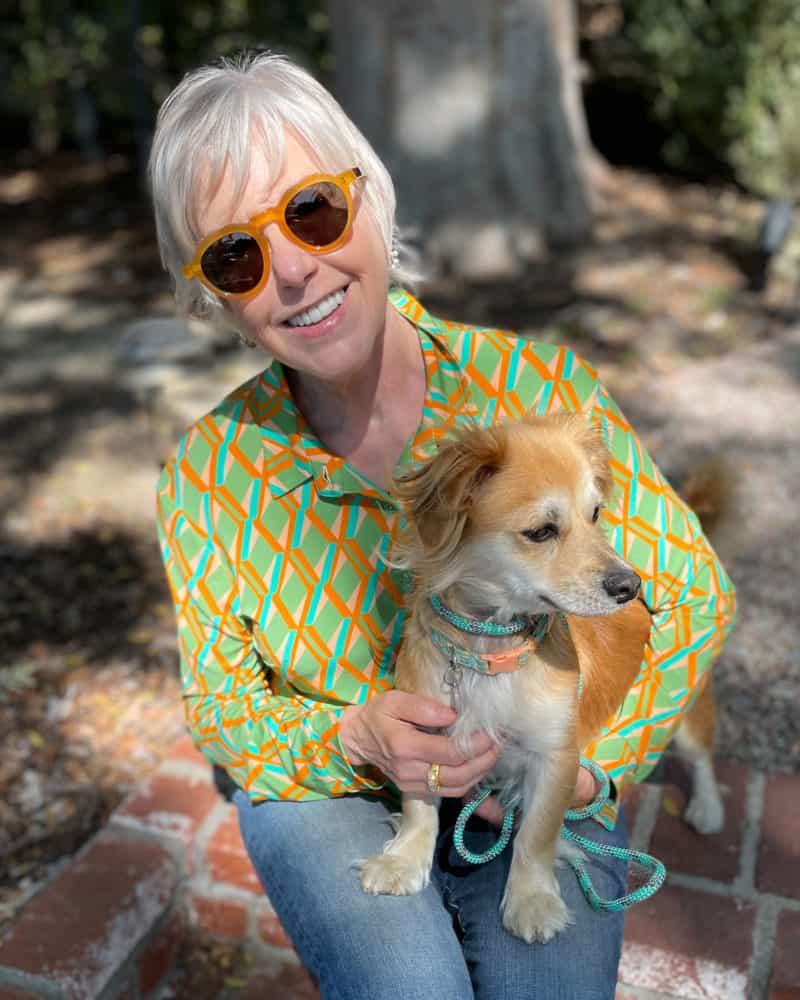 Susan B. wears See Eyewear sunglasses, a green print blouse, holds dog Bella. More at une femme d'un certain age.