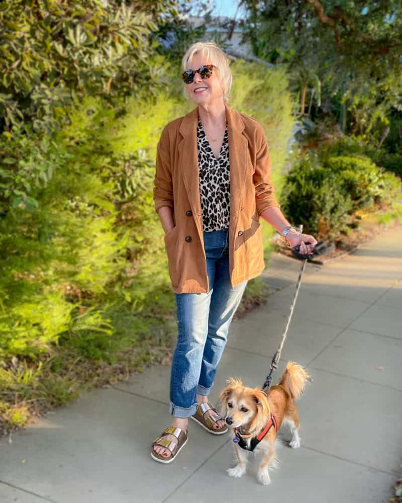Susan B. wears a corduroy blazer, leopard print top, jeans and gold Birkenstock sandals.
