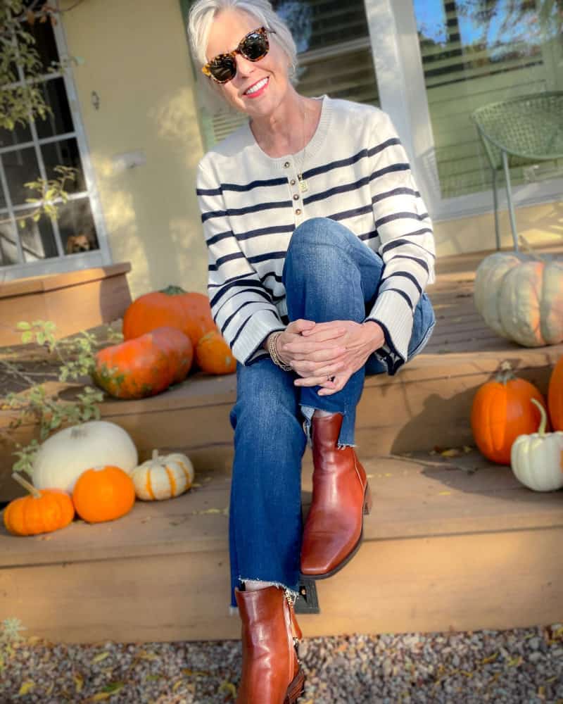 Susan B. wears a stripe La Ligne sweater, step-hem jeans, brown ankle boots.