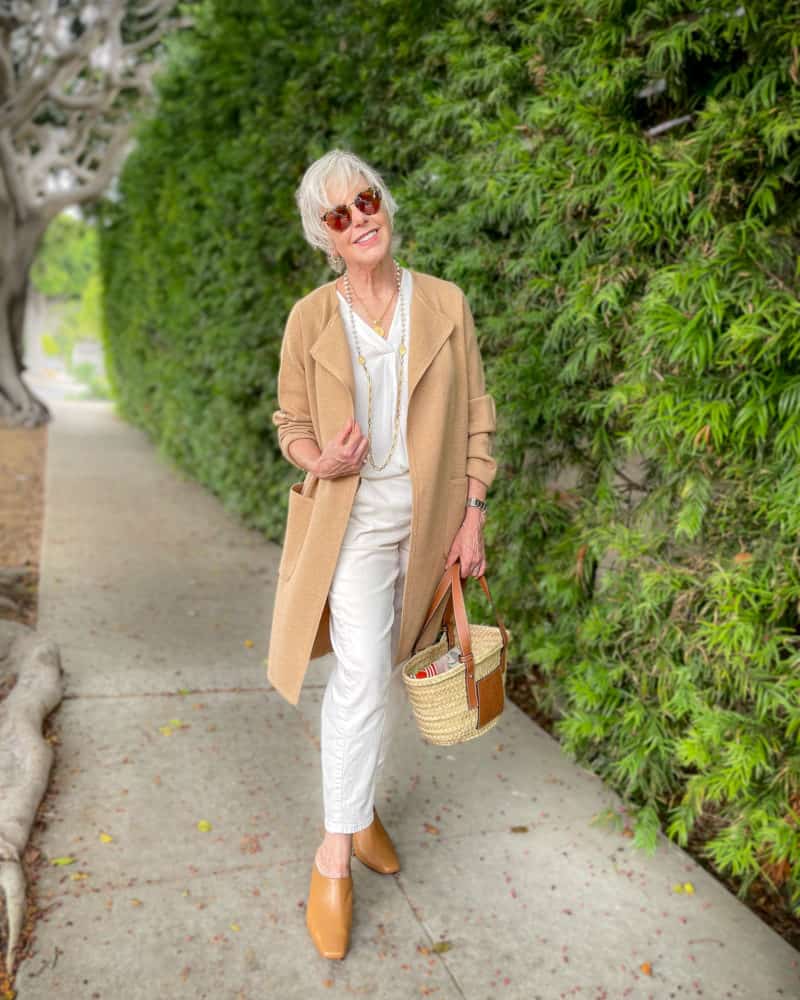 Susan B. wears a tonal outfit with a long J.Crew camel sweater jacket over an ivory column of color with Vince mules.