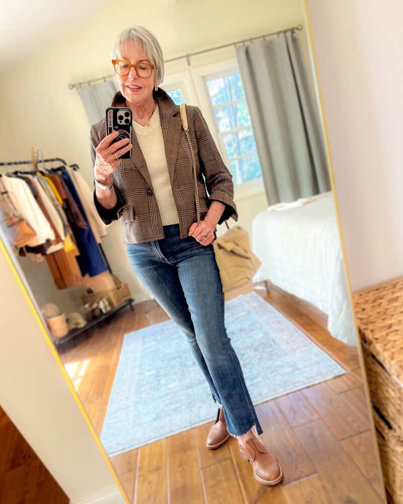 Susan B. wears a cropped plaid blazer, Saint Laurent LouLou puffer bag, a v-neck sweater vest, crop fray jeans and oxford shoes.