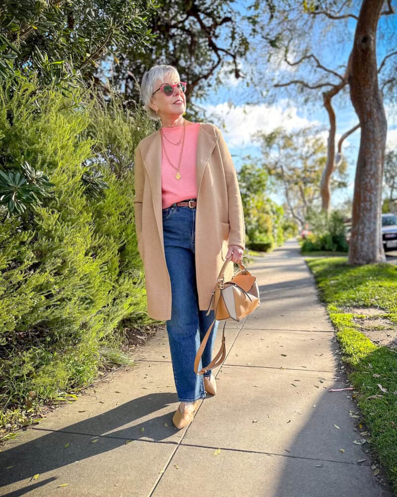 Susan B. wears a straight leg jeans outfit with J.Crew jeans, sweater, and sweater jacket. Loewe puzzle bag and Aeyde flats.