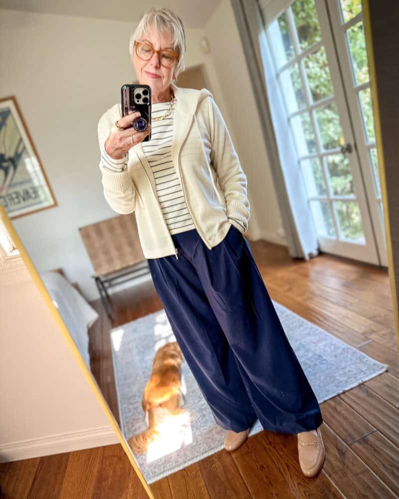 Susan B. wears a sporty chic outfit combo with a cashmere hoodie, striped tee, wide leg athleisure pants and classic loafers.
