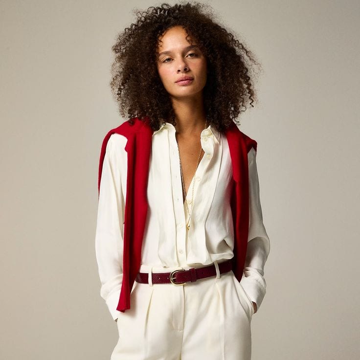 J.Crew Drapey Pleated button front shirt, worn with off white pants and red sweater draped over shoulders.