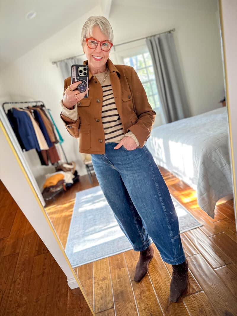 Susan B. takes a mirror selfie wearing a Ruti brown jacket, La Ligne striped sweater, Ruti barrel leg jeans, brown suede booties.