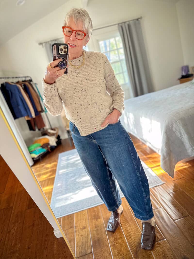 Susan B. takes a mirror selfie wearing a Tibi confetti sweater, Ruti barrel leg jeans, Tibi mules.