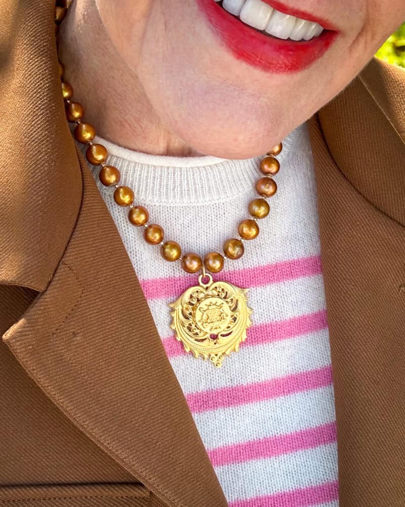 Detail: Susan B wears a French Kande gold pearl necklace with a gold medallion.