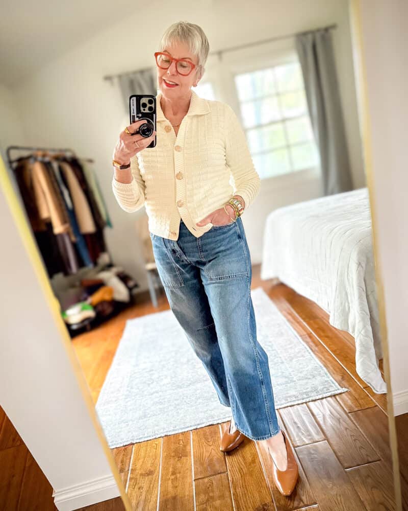 Susan B. wears an ivory sweater jacket with brown tee, barrel leg jeans and pointed-toe flats.