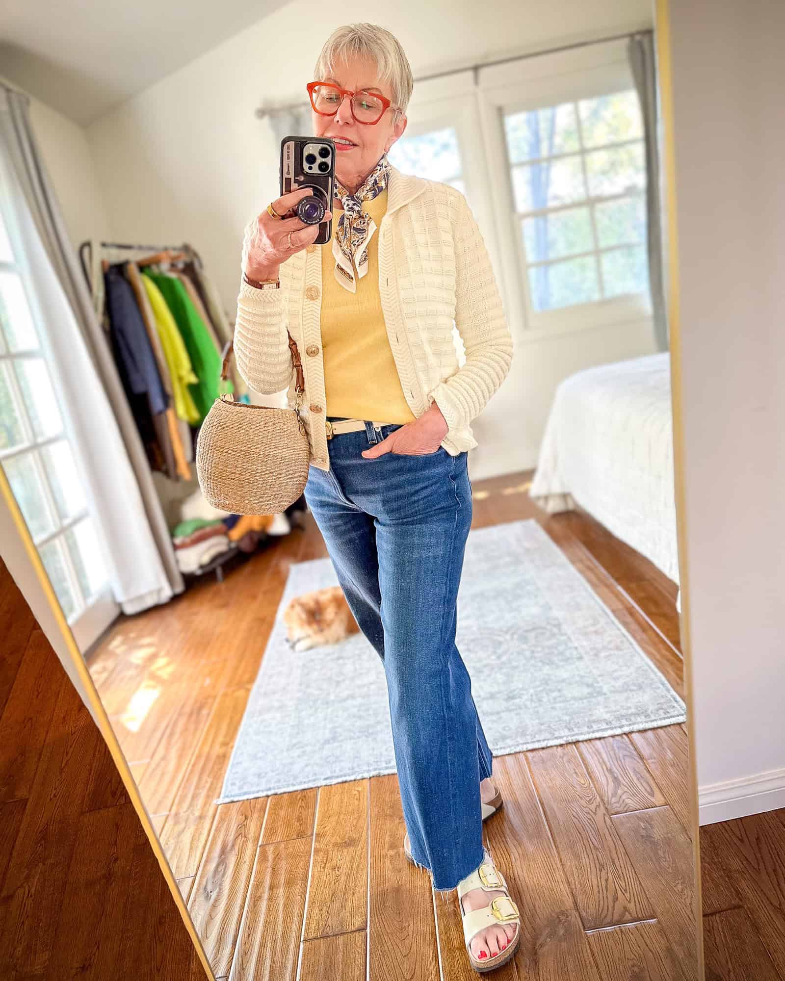 Susan B. wears a Talbot's ivory polo cardigan, Quince yellow cashmere tee, patterned bandana, straight leg jeans, Birkenstock Arizona sandals, carries a Clare V pot de miel bag.